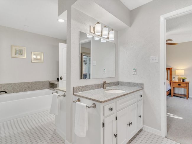 Ensuite bathroom with vanity, tile patterned floors, a garden tub, and baseboards | Image 25