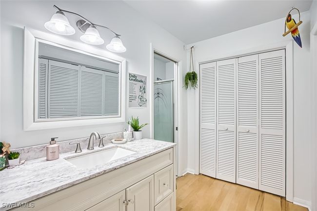 Full bathroom with a closet, wood finished floors, a shower stall, and vanity | Image 21