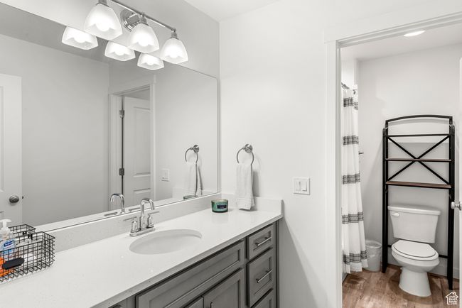 Full bathroom with curtained shower, toilet, vanity, and wood finished floors | Image 21