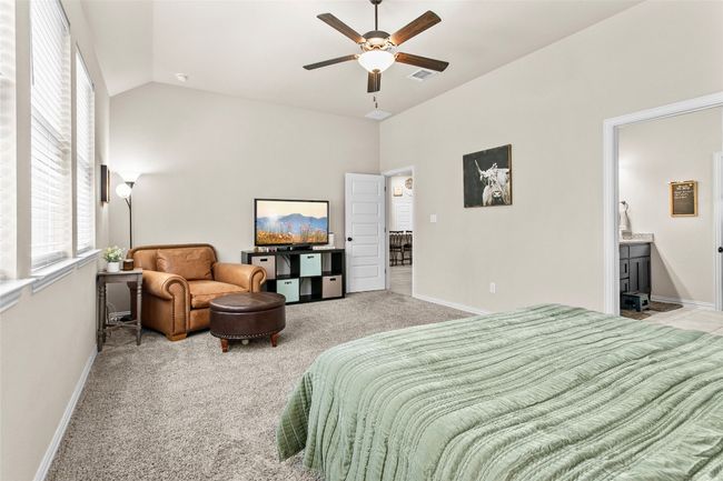 Bedroom featuring light carpet, ceiling fan, and connected bathroom | Image 14