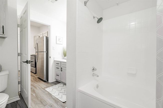 Full bathroom with vanity, toilet, wood-type flooring, and tiled shower / bath combo | Image 35