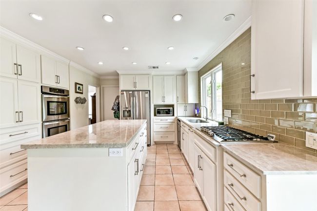 This kitchen with modern appliances, features a gas stove, double ovens, perfect for cooking and entertaining. | Image 21