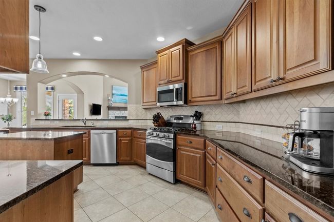 The heart of the home is ready to impress, with granite countertops, custom cabinetry, and a central island designed for both prep and conversation. | Image 10