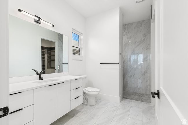 Full bath featuring vanity, baseboards, toilet, a marble finish shower, and marble finish floor | Image 21