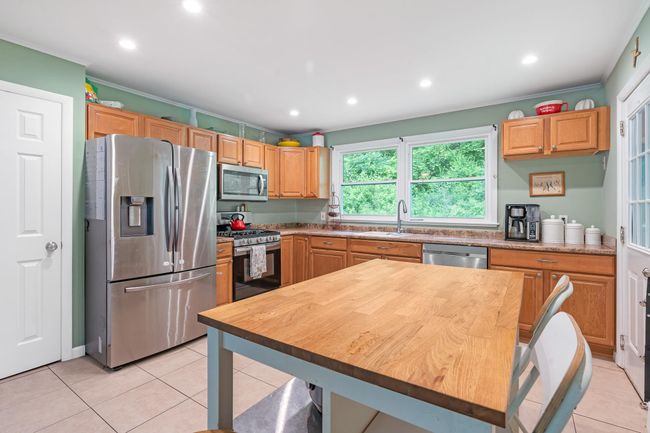 Kitchen with stainless steel appliances, a sink, light tile patterned flooring, recessed lighting, and ornamental molding | Image 19