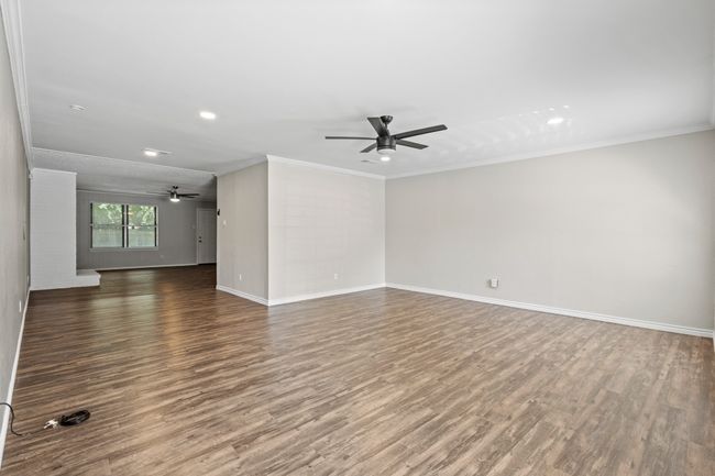 Unfurnished living room with ceiling fan, wood finished floors, crown molding, baseboards, and recessed lighting | Image 12