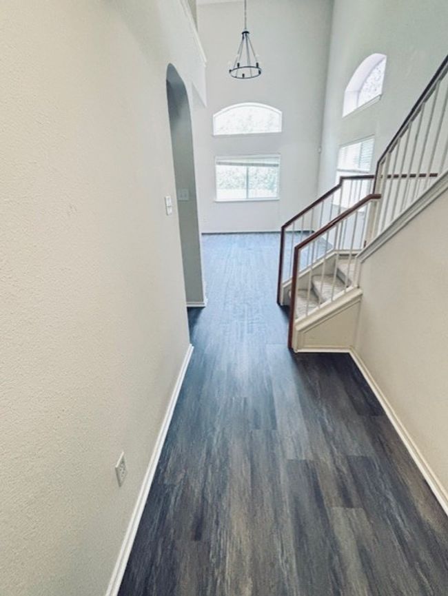 Entryway with arched walkways, wood finished floors, stairway, and a towering ceiling | Image 15