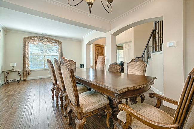 Dining area with wood-type flooring, arched walkways, baseboards, and ornamental molding | Image 26