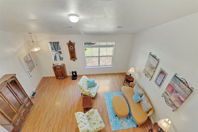 Living area with a textured ceiling and wood finished floors | Image 20