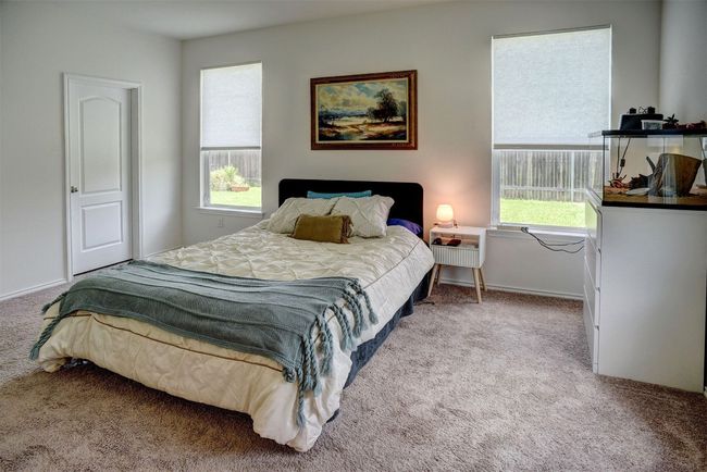Bedroom with carpet floors and multiple windows | Image 6