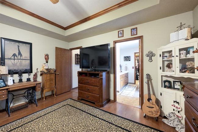 Office space with a raised ceiling, crown molding, and wood finished floors | Image 17