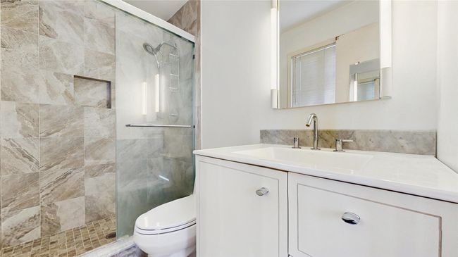 Bathroom with vanity, toilet, and a stall shower | Image 11