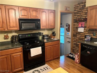 Kitchen with light wood-type flooring and black appliances | Image 3