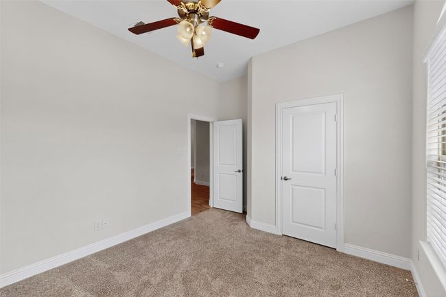Unfurnished bedroom featuring light colored carpet and ceiling fan | Image 18