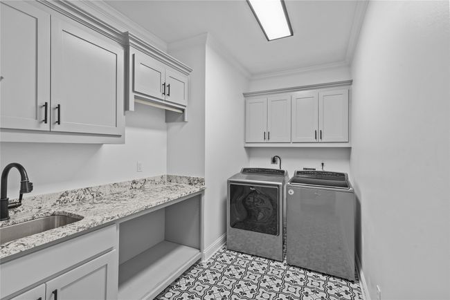 Washroom with independent washer and dryer, cabinet space, and crown molding | Image 19