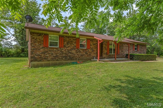 Ranch-style house with a front lawn, a patio, and brick siding | Image 4