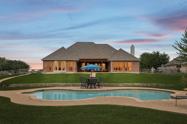 Pool at dusk featuring an outdoor pool and a patio area | Image 34