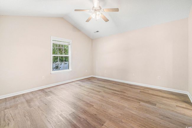Empty room featuring light wood-style flooring, ceiling fan, and lofted ceiling | Image 20