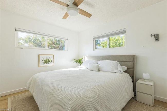 Bedroom featuring light wood-style floors, baseboards, ceiling fan, and a textured ceiling | Image 28