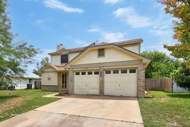 Traditional home featuring fence, an attached garage, driveway, brick siding, and a front yard | Image 30