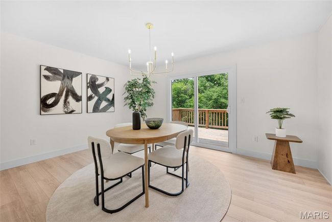 Dining space with a chandelier and light wood finished floors | Image 20