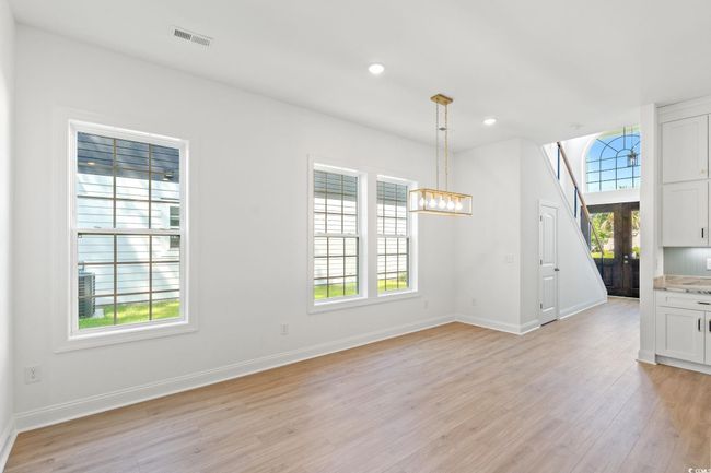 Unfurnished dining area featuring light wood-style floors, recessed lighting, and a chandelier | Image 9