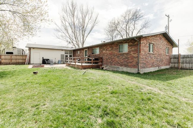 Back of property featuring fence private yard, crawl space, a patio area, brick siding, and a lawn | Image 37