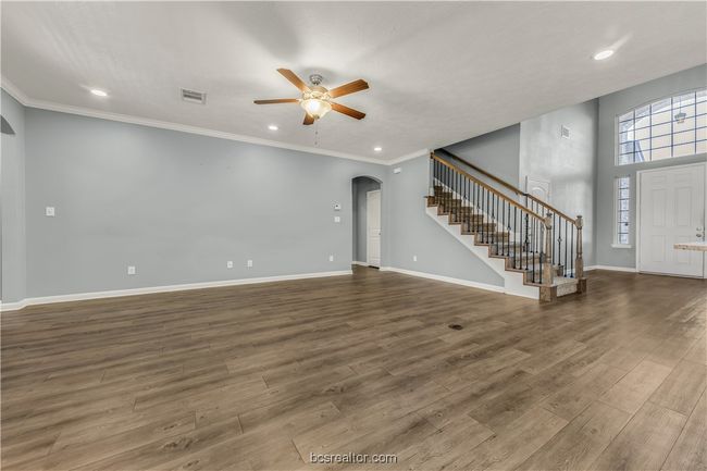 Unfurnished living room featuring hardwood / wood-style flooring, crown molding, and ceiling fan | Image 5