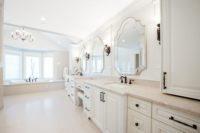 Bathroom featuring a bath, vaulted ceiling, vanity, tile patterned floors, and an inviting chandelier | Image 24