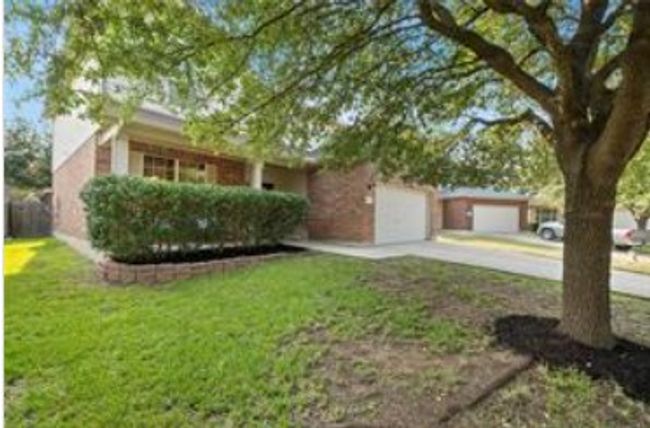 View of property hidden behind natural elements with concrete driveway and a front yard | Image 26