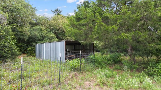 View of yard with a pole building, an outbuilding, and a wooded view | Image 39