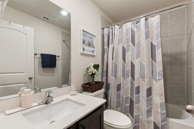 Full bathroom with shower / bath combination with curtain, visible vents, toilet, and vanity | Image 24