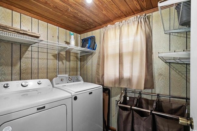 Washroom featuring washing machine and clothes dryer and wood ceiling | Image 37