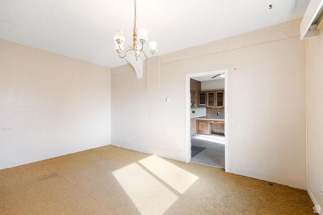 Spare room with an inviting chandelier and light carpet | Image 9