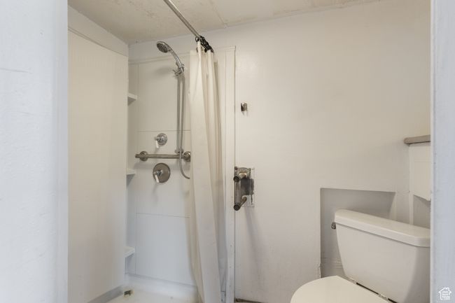 Full bathroom with a shower with shower curtain and toilet | Image 19
