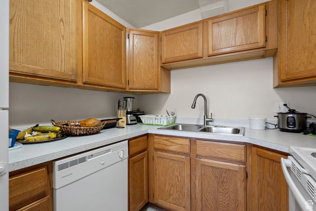 Kitchen with dishwasher, light countertops, range, and brown cabinetry | Image 27