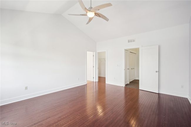 Unfurnished bedroom featuring visible vents, high vaulted ceiling, baseboards, and hardwood / wood-style floors | Image 14
