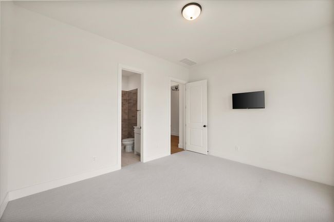 Bedroom 3 at the front of the house with a view of the pond and ensuite bathroom with shower | Image 23