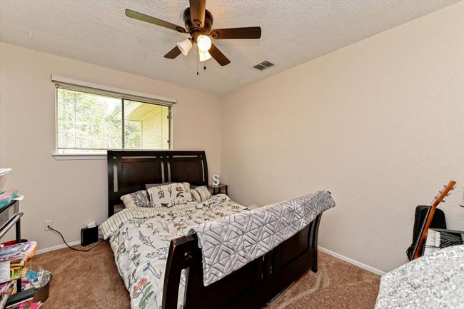 Bedroom with carpet flooring, a textured ceiling, baseboards and ceiling fan | Image 19
