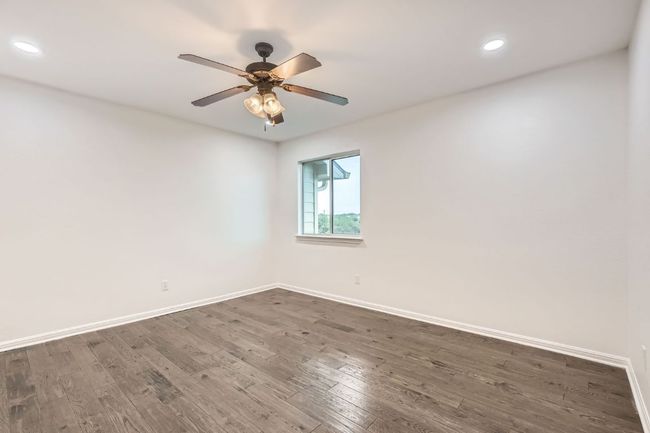 Unfurnished room featuring dark wood-type flooring, baseboards, recessed lighting, and ceiling fan | Image 15