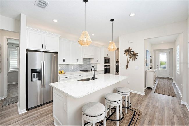 Move in today! Laundry room has custom cabinetry and folding space with a pocket door to close off sound and room. | Image 9