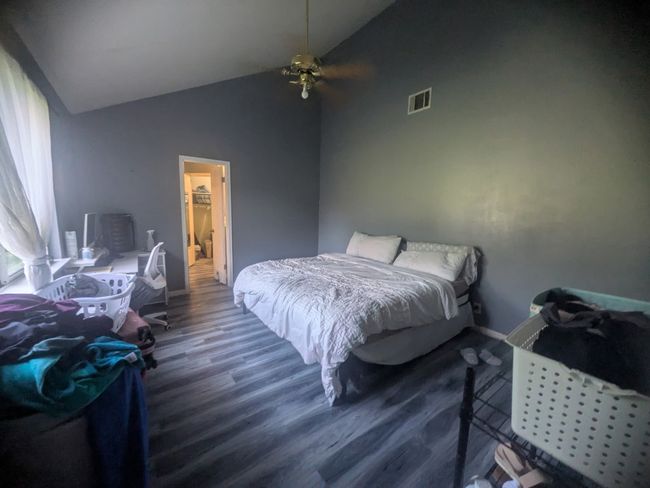 Bedroom with wood finished floors, high vaulted ceiling, and ceiling fan | Image 5