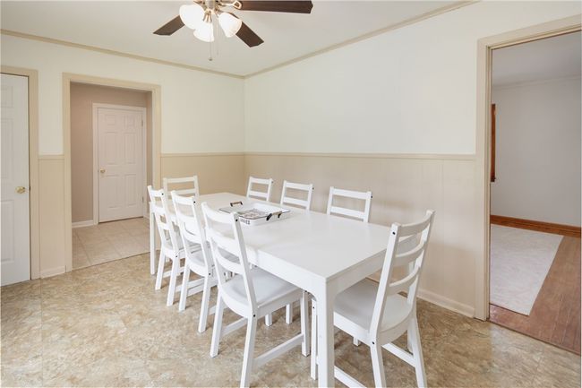 Dining room featuring ceiling fan, a wainscoted wall, and ornamental molding | Image 10
