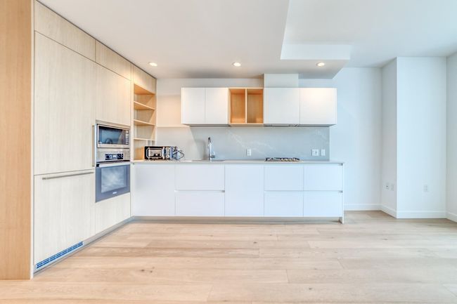 Kitchen featuring open shelves, stainless steel appliances, light wood-style flooring, a sink, and modern cabinets | Image 5