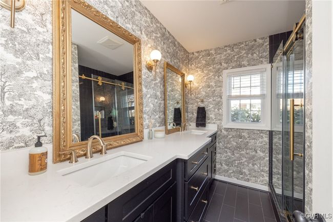 Bathroom with visible vents, a shower stall, double vanity, wallpapered walls, and a sink | Image 24