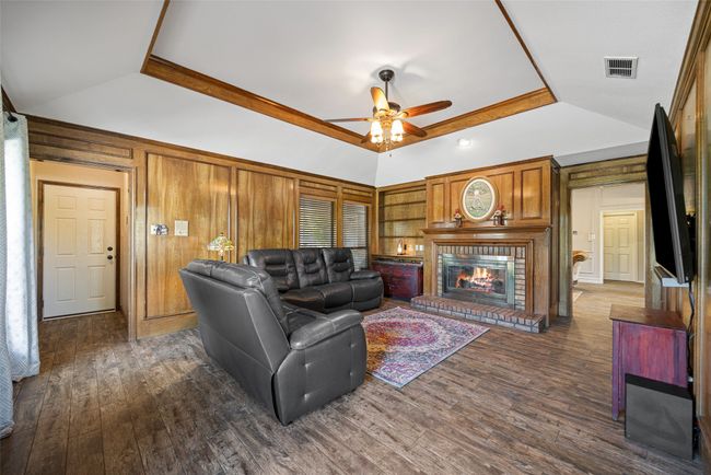 Living room with visible vents, ceiling fan, dark wood finished floors, and vaulted ceiling | Image 15