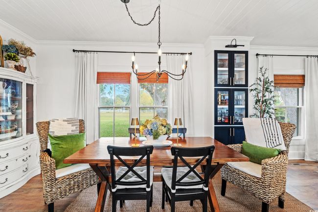 Dining room featuring crown molding, wood finished floors, and a chandelier | Image 10