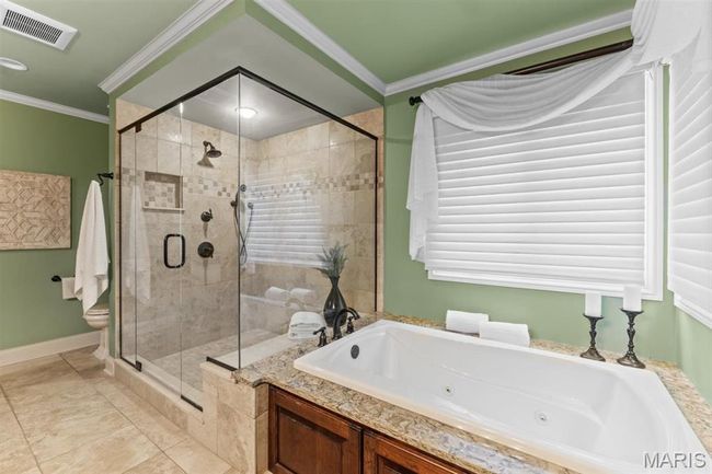 Full bathroom with a tub with jets, a shower stall, crown molding, and tile patterned flooring | Image 40