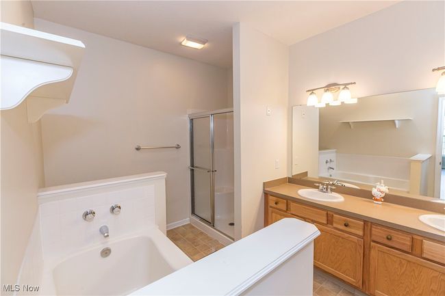 Bathroom featuring a double vanity, bathtub and shower | Image 5