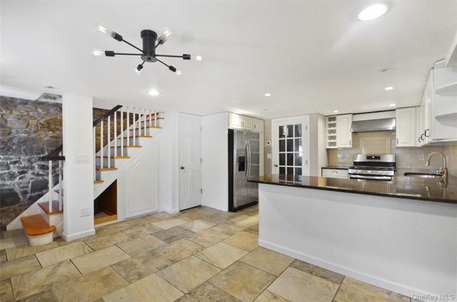 Kitchen with open shelves, white cabinetry, stainless steel appliances, a peninsula, and recessed lighting | Image 9